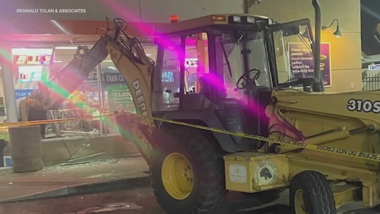 The video shows thieves using a backhoe to break into the store with an employee inside
